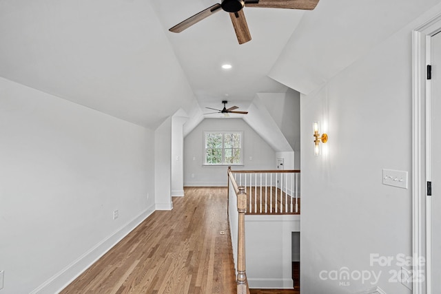 bonus room featuring light wood-style flooring, baseboards, lofted ceiling, and a ceiling fan