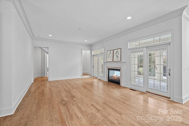 unfurnished living room featuring baseboards, a multi sided fireplace, light wood-style floors, and ornamental molding