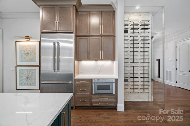 kitchen with crown molding, dark wood-style floors, visible vents, and appliances with stainless steel finishes