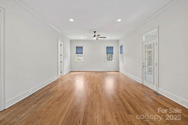 empty room with light wood-style flooring, crown molding, baseboards, and ceiling fan