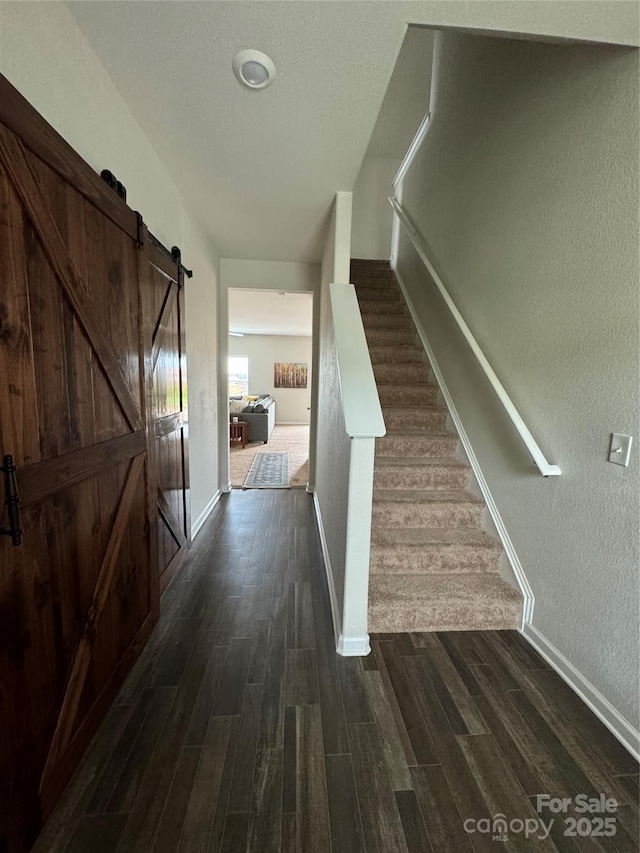 interior space featuring a barn door and dark hardwood / wood-style floors