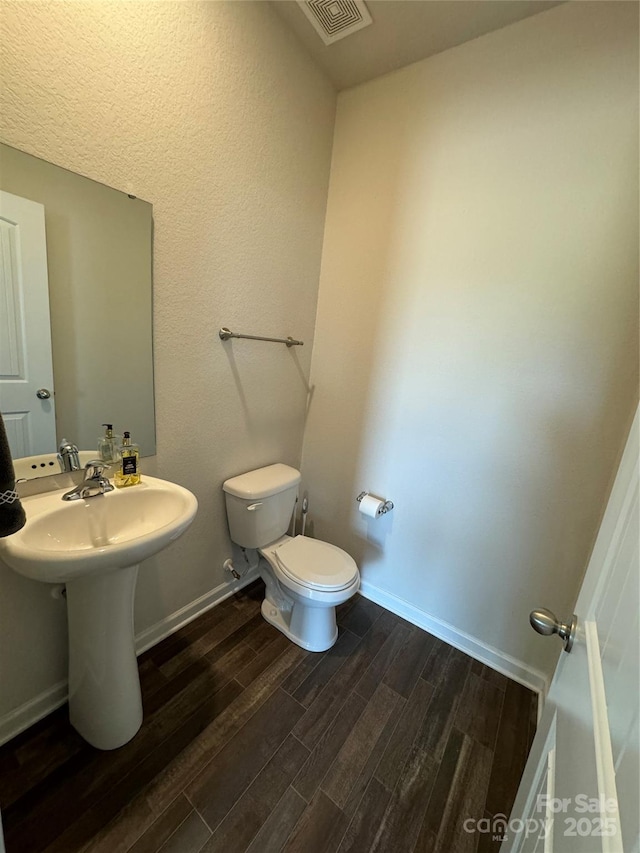 bathroom featuring hardwood / wood-style flooring and toilet