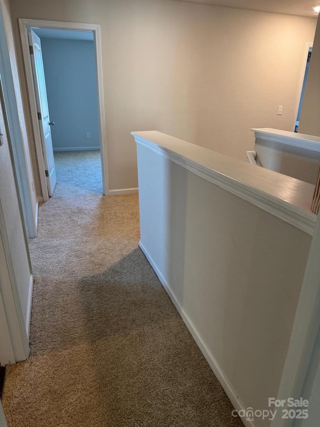 hallway featuring light colored carpet