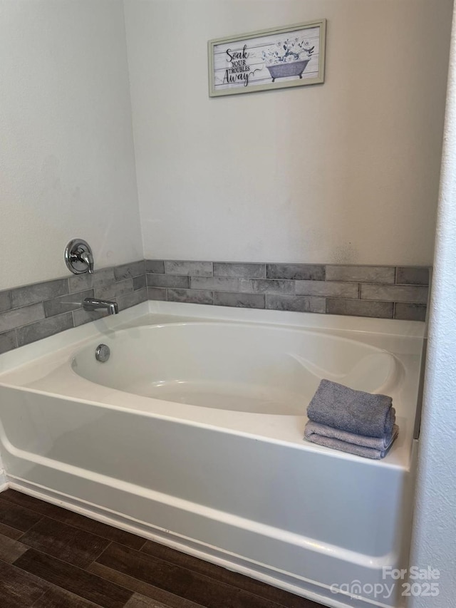 bathroom with hardwood / wood-style flooring and a tub