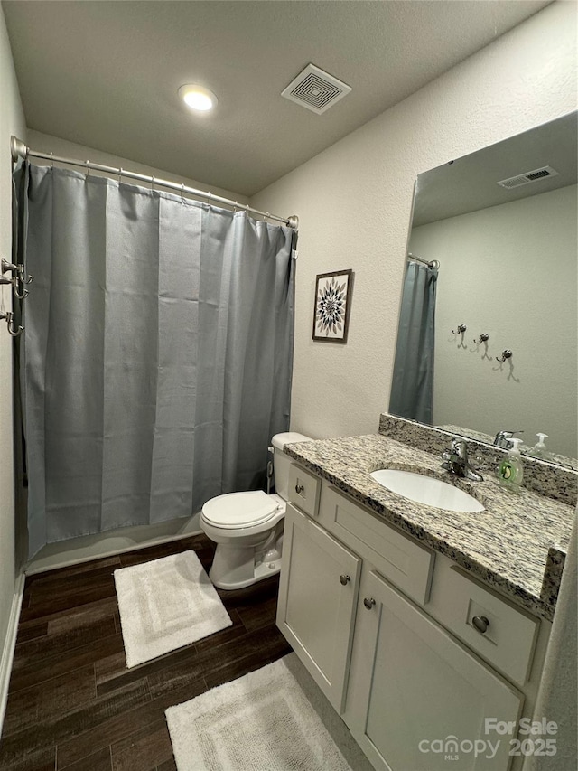 bathroom with vanity, toilet, and curtained shower