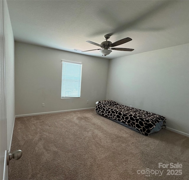 unfurnished bedroom with ceiling fan, carpet floors, and a textured ceiling