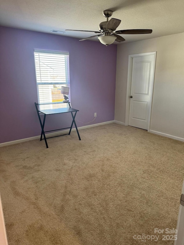 carpeted empty room featuring ceiling fan and a textured ceiling