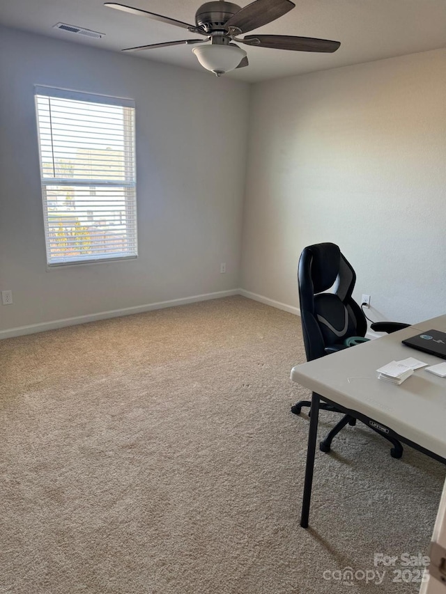 carpeted home office featuring ceiling fan