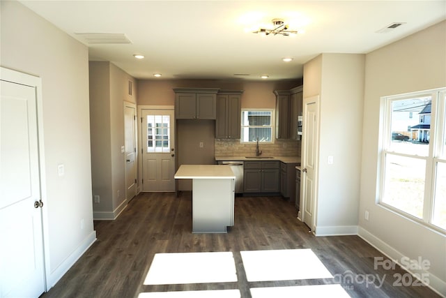 kitchen featuring sink, gray cabinetry, tasteful backsplash, dishwasher, and a kitchen island