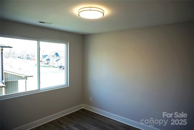 unfurnished room with dark wood-type flooring