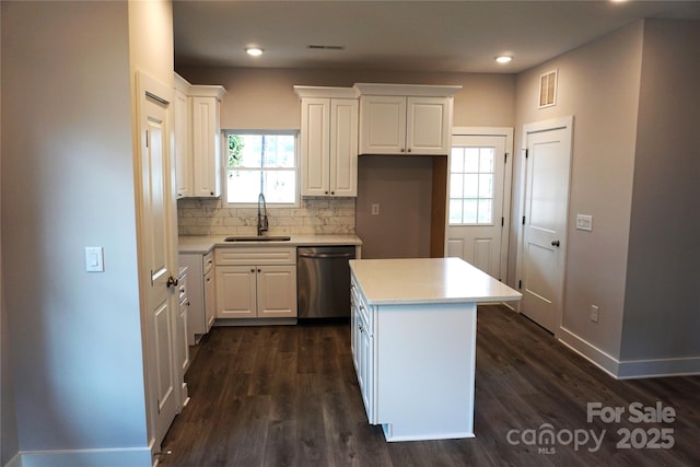 kitchen with sink, dishwasher, white cabinetry, a center island, and decorative backsplash