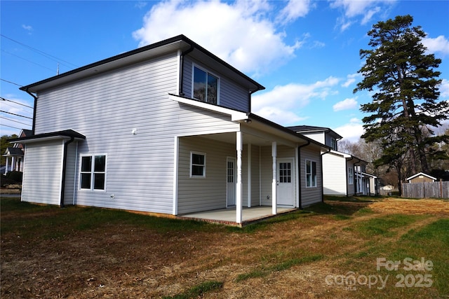 back of house featuring a patio area and a lawn