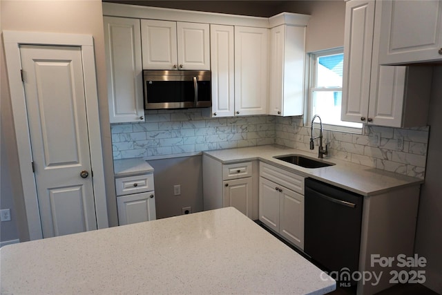 kitchen featuring backsplash, dishwasher, sink, and white cabinets