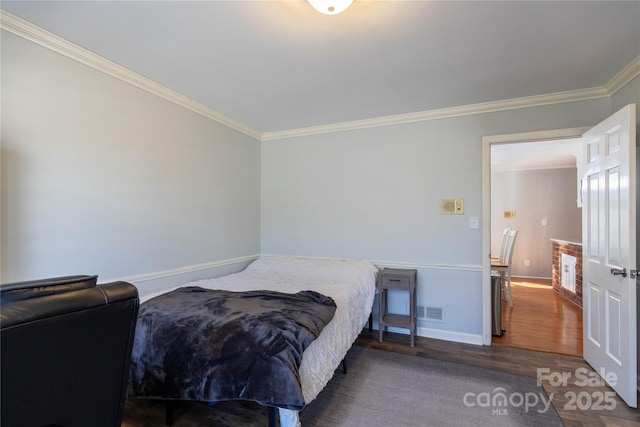 bedroom with crown molding and dark hardwood / wood-style flooring