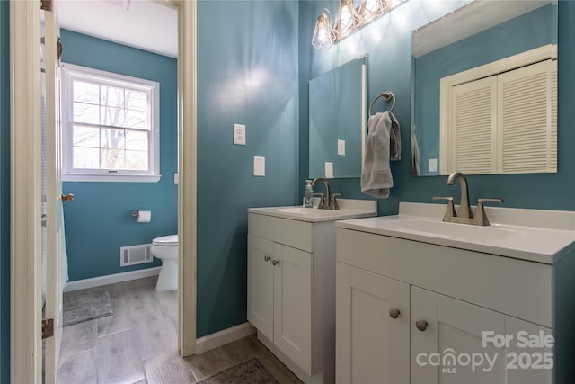 bathroom with hardwood / wood-style flooring, vanity, and toilet