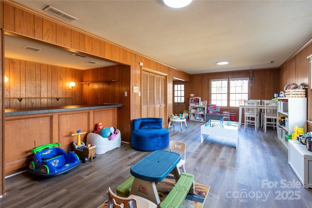 playroom featuring ornamental molding, dark hardwood / wood-style floors, and a textured ceiling