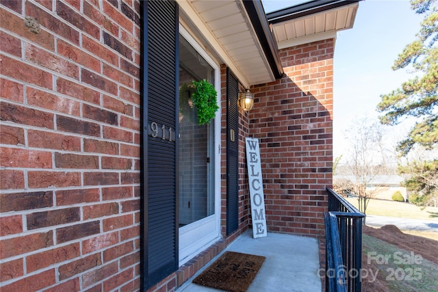 view of exterior entry featuring brick siding