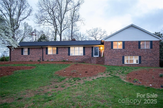 tri-level home featuring a front yard, brick siding, and a chimney
