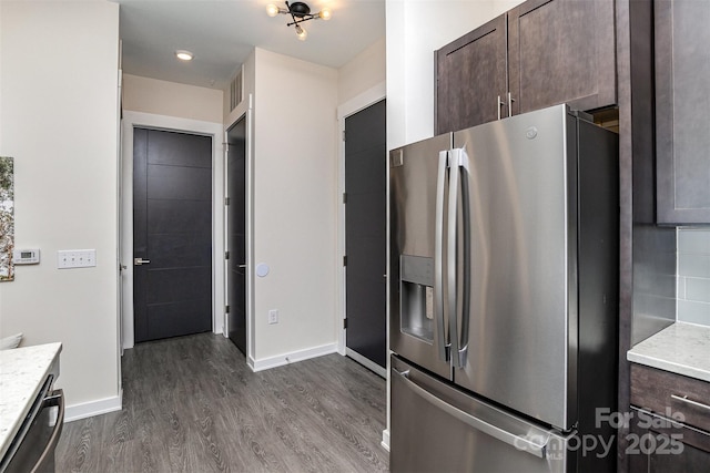 kitchen with dark brown cabinetry, backsplash, wood-type flooring, and appliances with stainless steel finishes