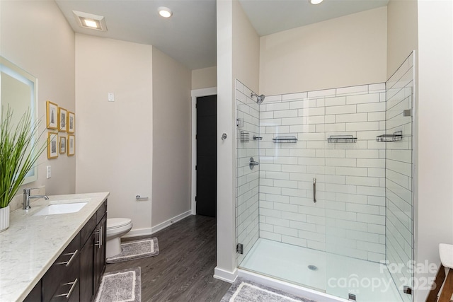 bathroom with hardwood / wood-style flooring, vanity, toilet, and walk in shower