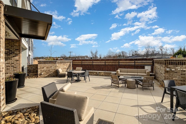 view of patio with an outdoor living space with a fire pit