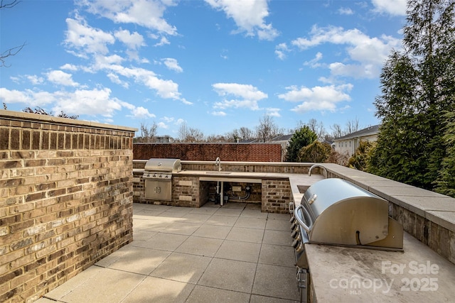 view of patio / terrace featuring a grill, exterior kitchen, and sink