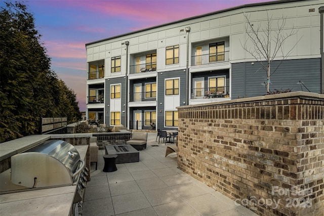 patio terrace at dusk with grilling area and exterior kitchen