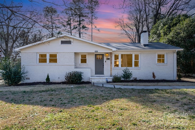 single story home with a lawn