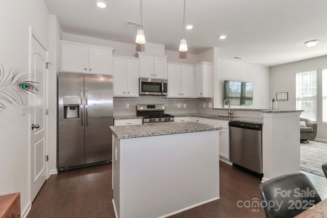 kitchen featuring appliances with stainless steel finishes, a center island, and white cabinets