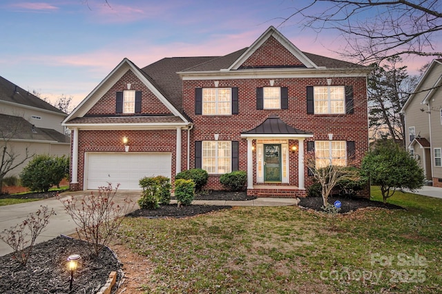 view of front of home with brick siding, a standing seam roof, a garage, driveway, and a front lawn