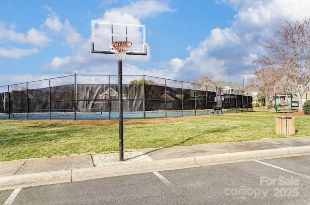 view of sport court featuring fence and a yard