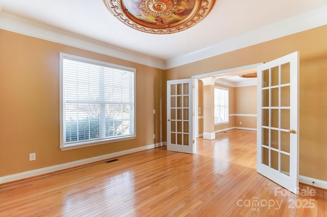 unfurnished room with french doors, crown molding, wood-type flooring, and baseboards