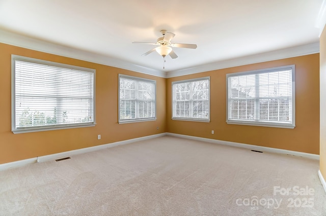 carpeted spare room with ceiling fan, visible vents, and baseboards