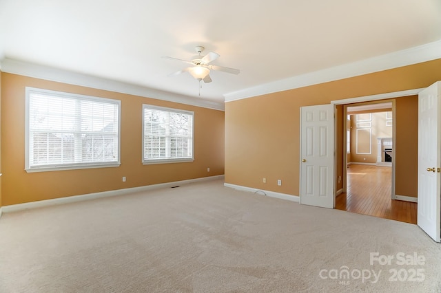 carpeted empty room featuring ceiling fan and baseboards