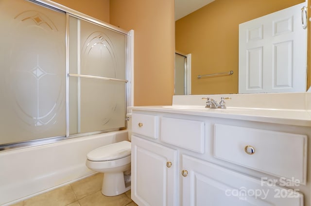 full bathroom with bath / shower combo with glass door, vanity, toilet, and tile patterned floors