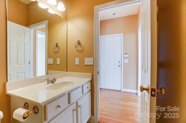 half bath featuring wood finished floors and vanity