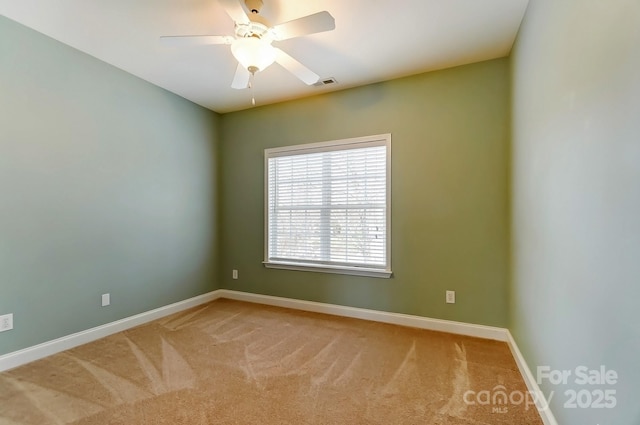 carpeted spare room featuring visible vents, ceiling fan, and baseboards