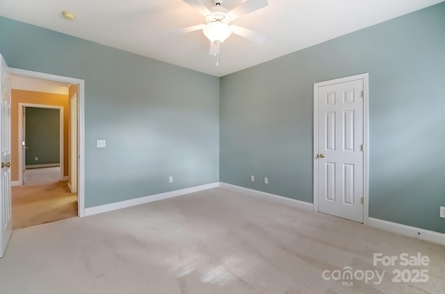 empty room with ceiling fan, carpet, and baseboards