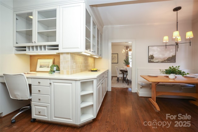 kitchen featuring pendant lighting, dark hardwood / wood-style flooring, decorative backsplash, and white cabinets