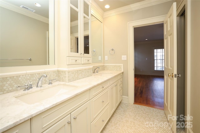 bathroom with tasteful backsplash, ornamental molding, and vanity