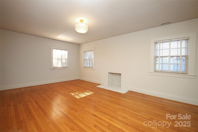 unfurnished room featuring plenty of natural light and light hardwood / wood-style floors