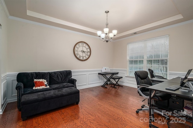 office space with crown molding, a tray ceiling, wood-type flooring, and a chandelier