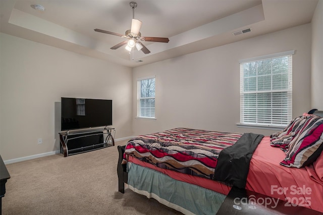 bedroom featuring carpet floors, ceiling fan, and a tray ceiling