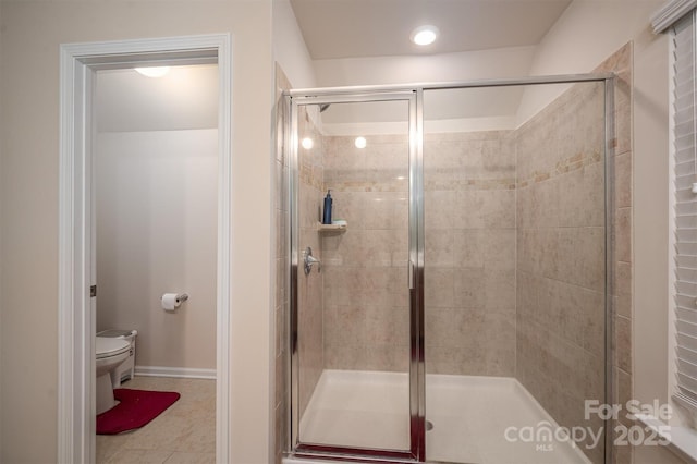 bathroom with toilet, tile patterned flooring, and a shower with door