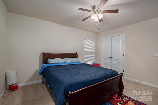 bedroom featuring light carpet, ceiling fan, and a closet