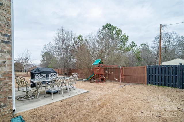 view of yard featuring a playground and a patio