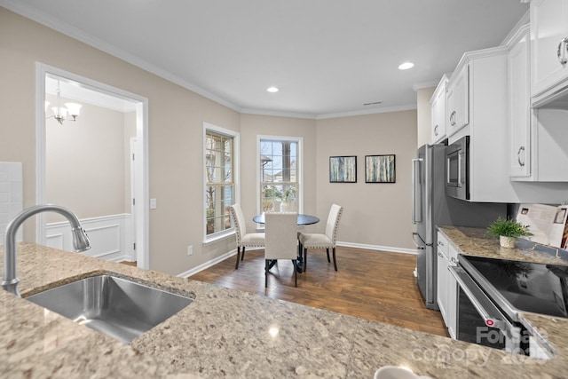 kitchen featuring light stone counters, sink, and white cabinets