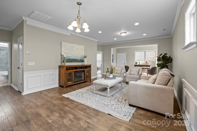 living room featuring ornamental molding, dark hardwood / wood-style floors, and a chandelier