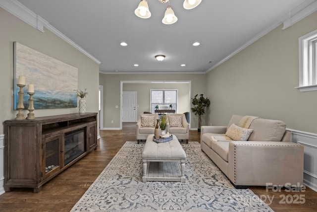 living room with an inviting chandelier, dark wood-type flooring, and ornamental molding