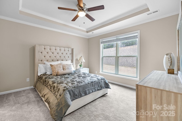 bedroom featuring light carpet and a tray ceiling